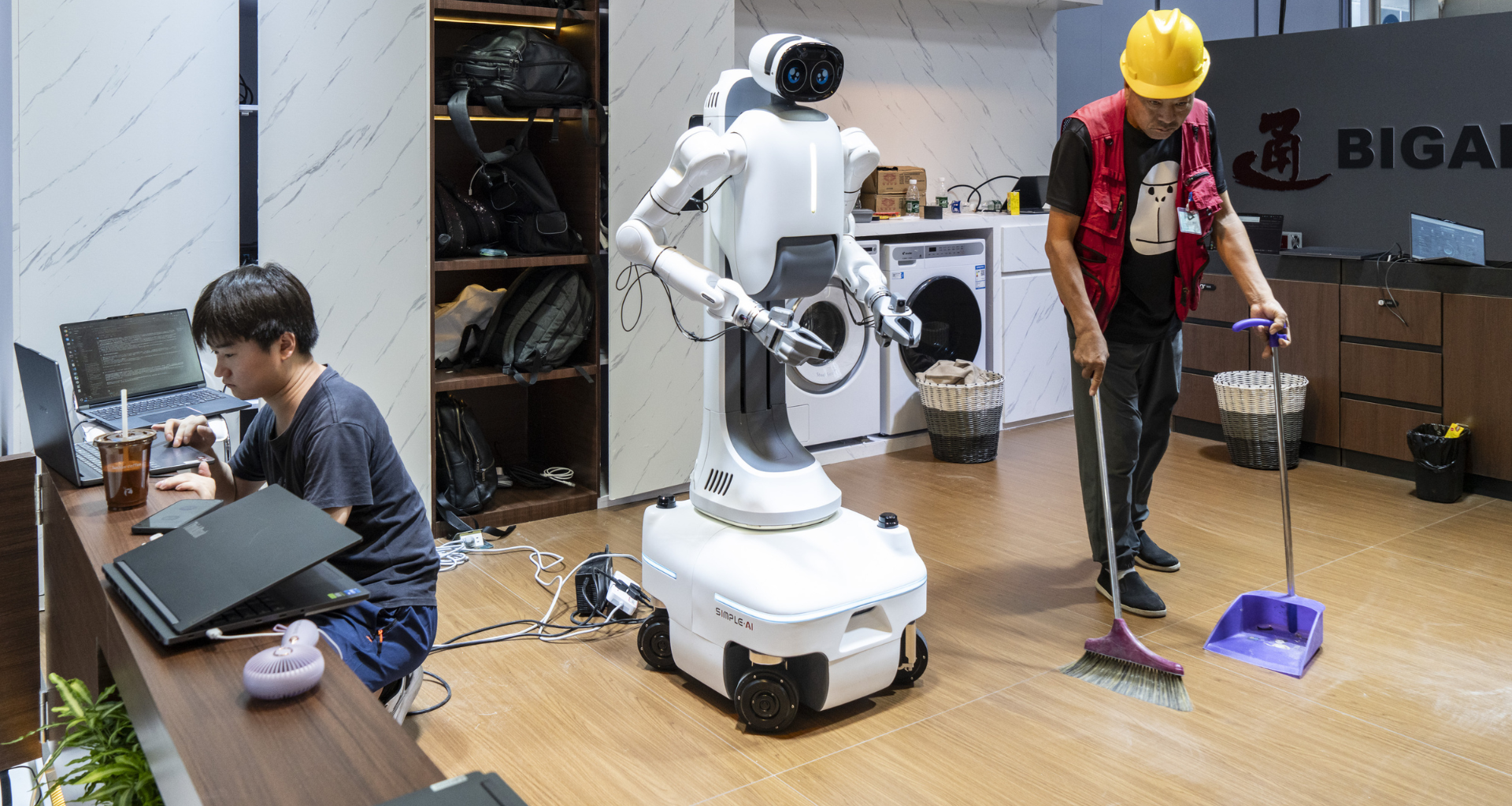 a person sweeping the floor in front of a robot