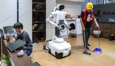a person sweeping the floor in front of a robot