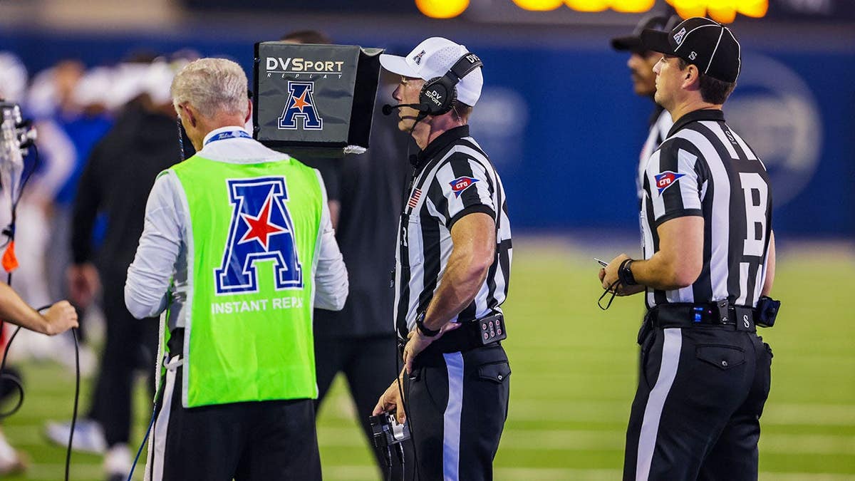 Officials review Tulsa's two-point conversion attempt during a football game.