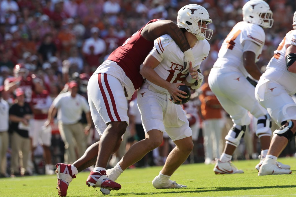 Oklahoma Sooners defensive line Trent Wilson (90) tackles Texas Longhorns quarterback Arch Manning (16) during the first half of a game at Cotton Bowl in Dallas, Texas, Saturday, Oct. 10, 2026.