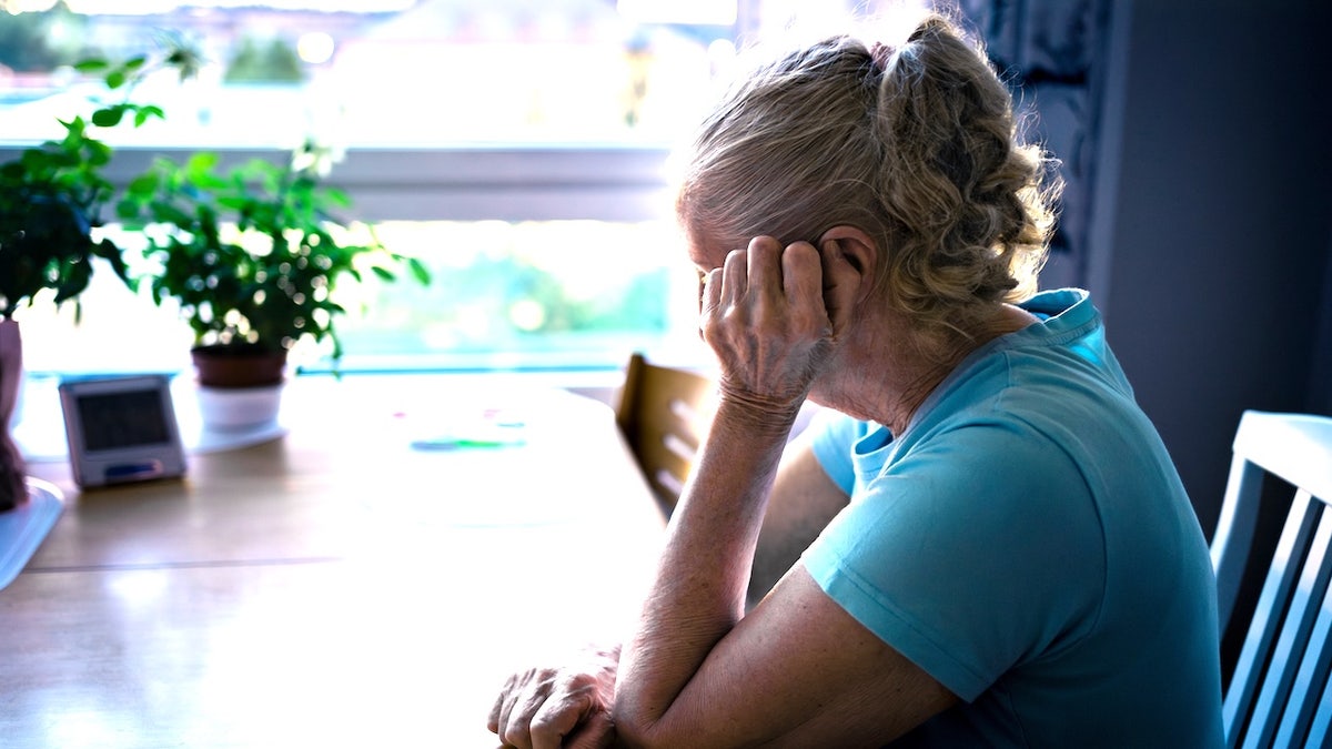 Older woman with Alzheimer's sitting at a table