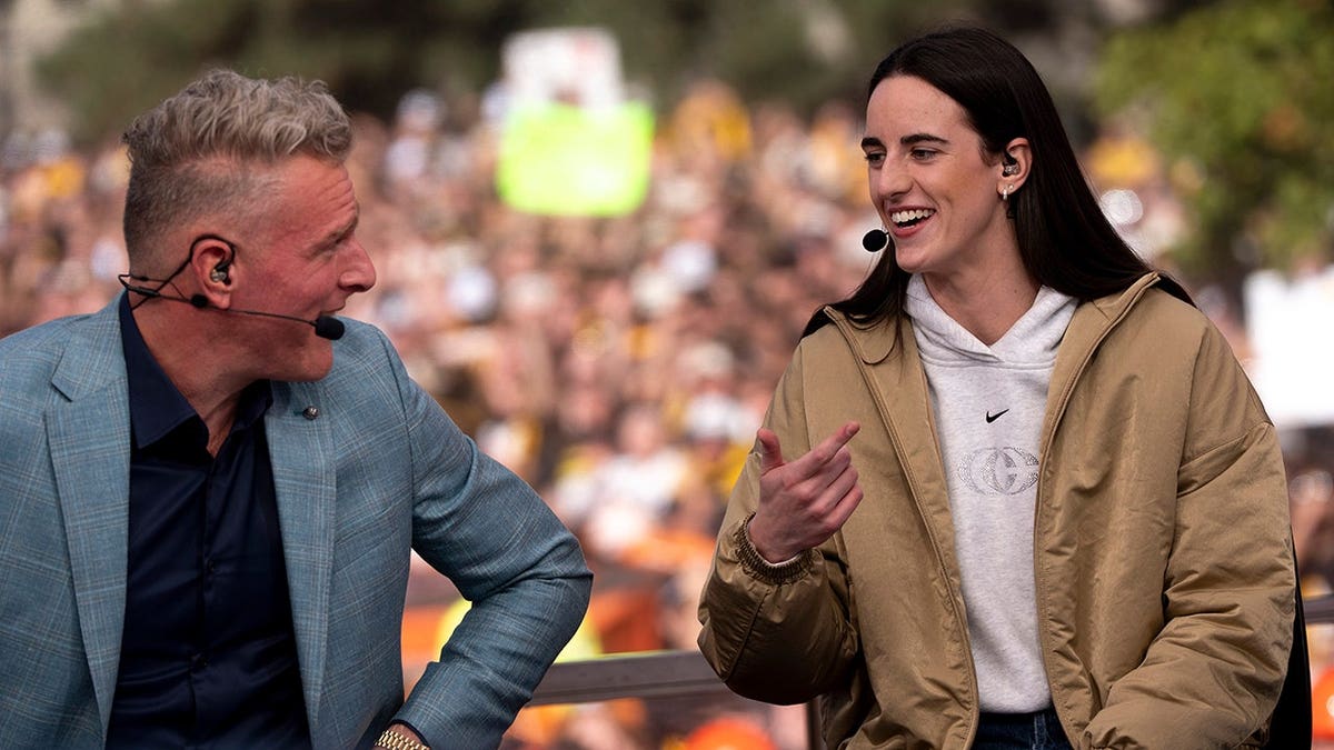 Pat McAfee listens to Caitlin Clark during a live ESPN College GameDay broadcast in downtown Iowa City, Iowa.