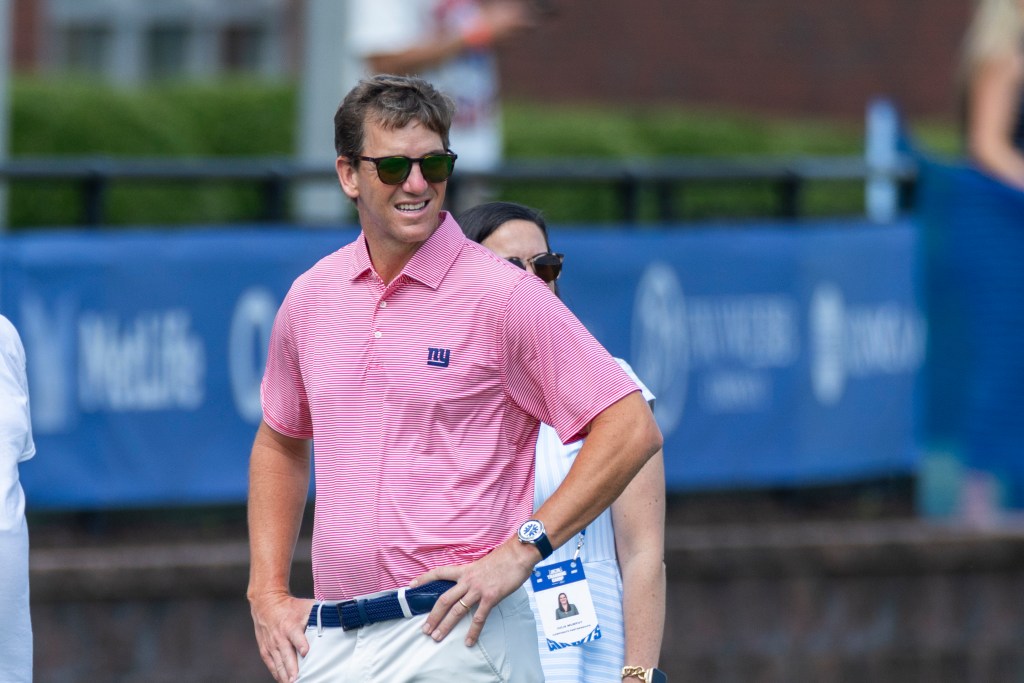 Retired New York Giants quarterback Eli Manning watches training camp.