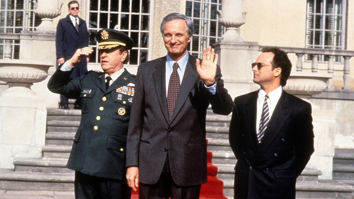 Rip Torn, Alan Alda and Kevin Pollak walking down a red carpet in a scene from the film 'Canadian Bacon', 1995.