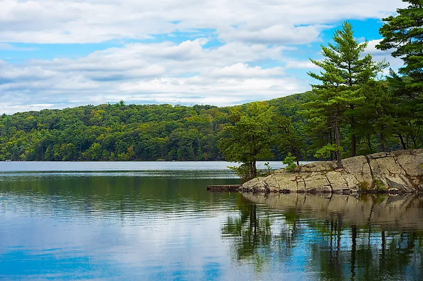 A lake with a rocky, wooded shoreline in Sterling Forest State Park, New York.