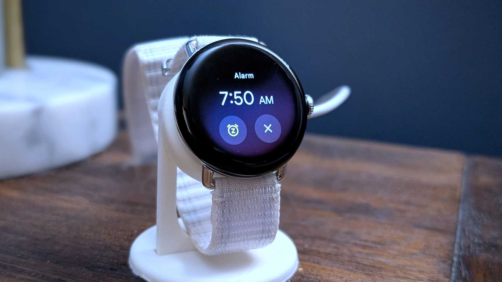 Smartwatch on a bedside table with alarm going off.