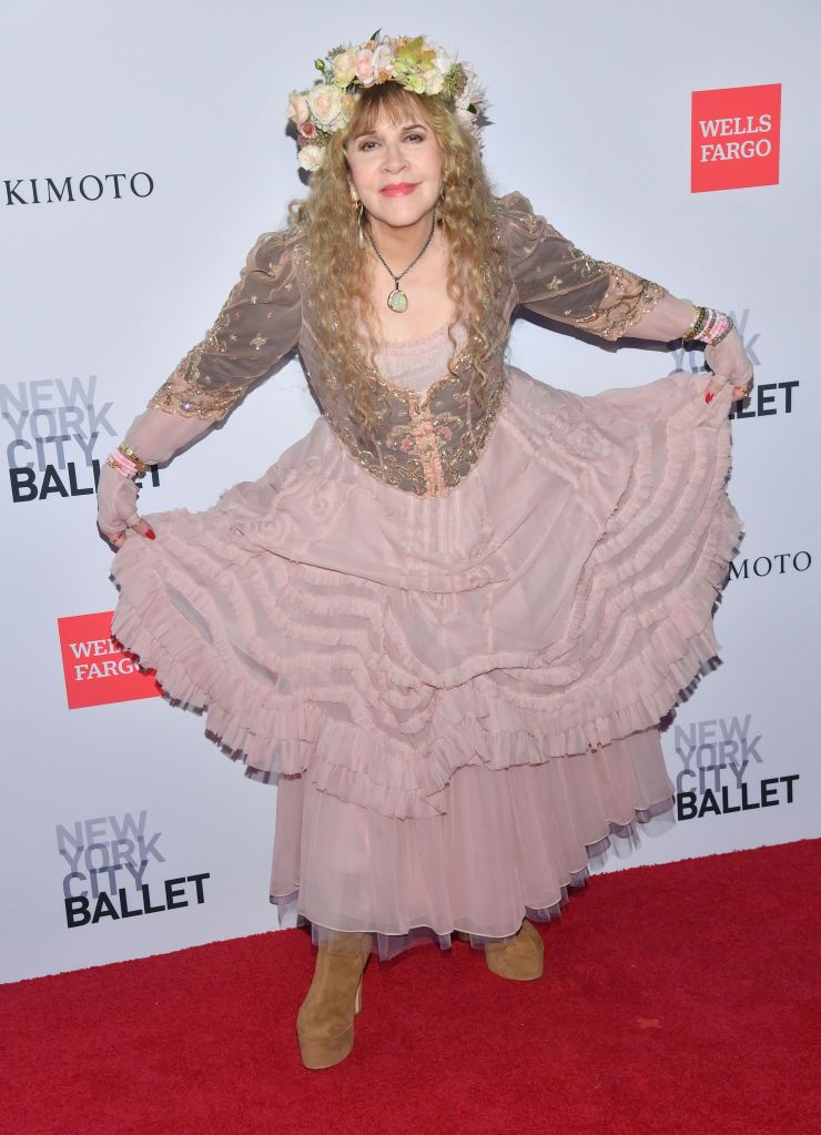 Stevie Nicks poses on the red carpet at the New York City Ballet Fall Gala, wearing a tiered pink dress and a floral crown.