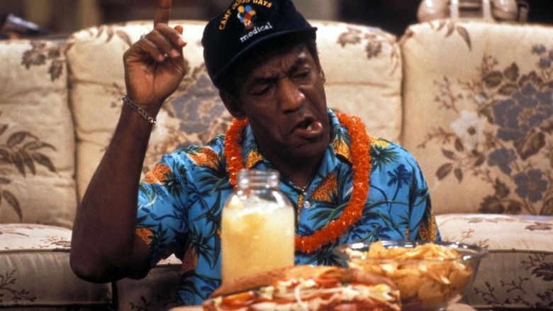 Cliff Huxtable in front of a sandwich, chips, and jar of juice in The Cosby Show