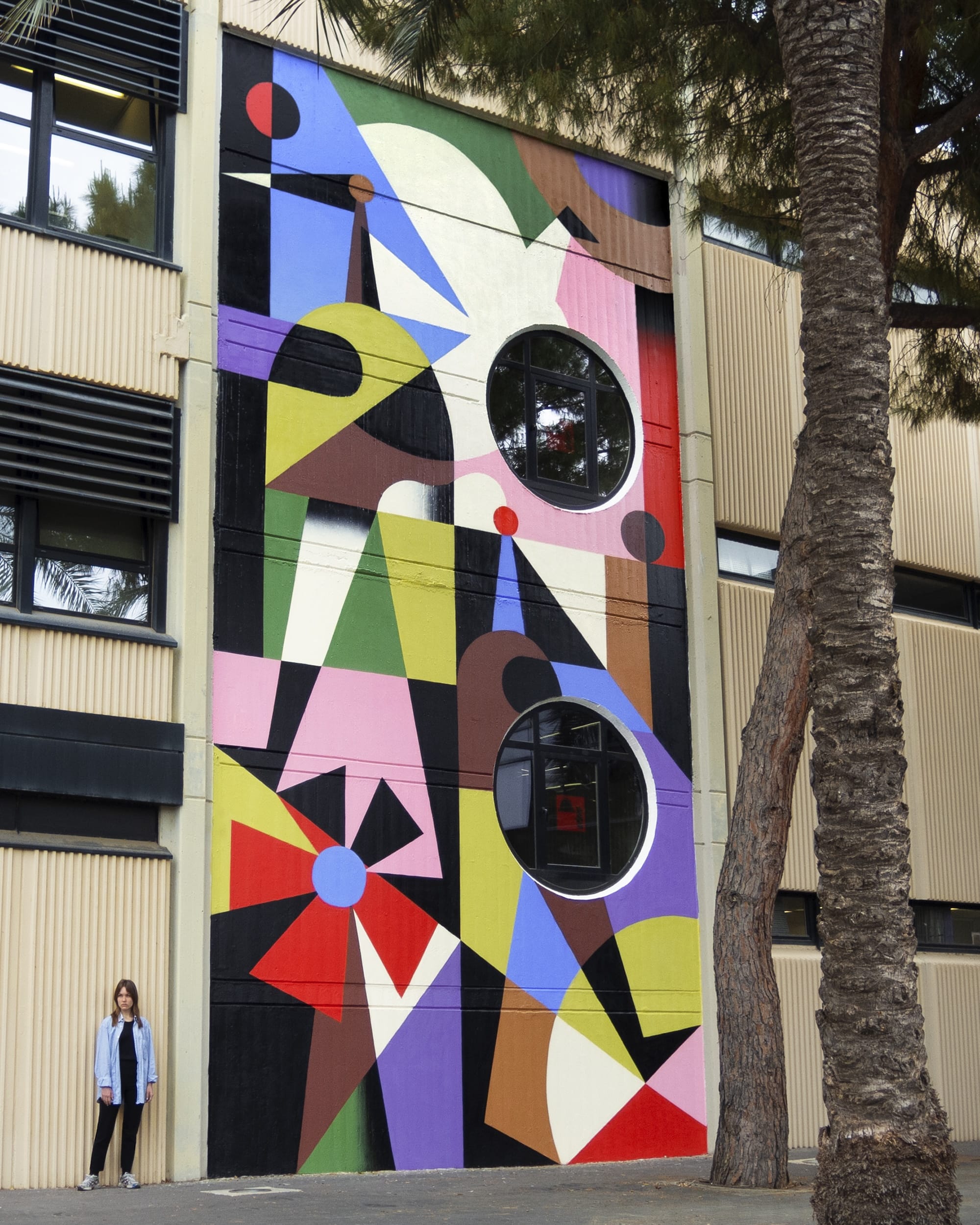 a colorful, geometric abstract mural on an urban wall