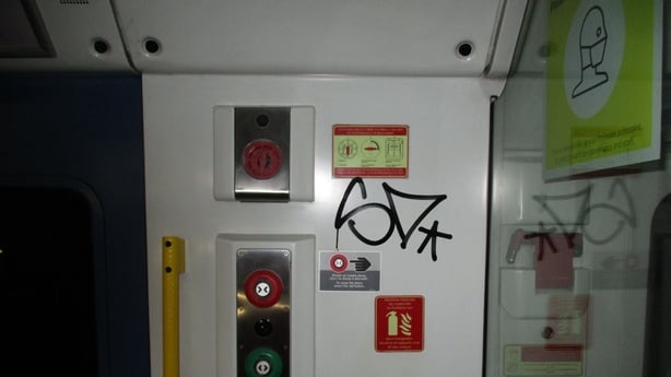 black text graffiti on a wall of a train