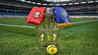 The Liam MacCarthy Cup is pictured at Croke Park in Dublin alongside an official match sliotar and the jerseys of Cork and Tipperary