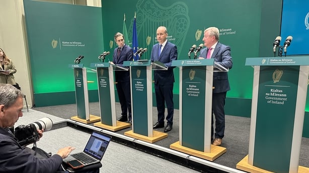 Simon Harris, Micheál Martin and Seán Canney at a press conference for the revised National Development Plan