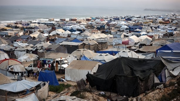 Tents and shelters for Palestinians displaced by conflict are erected at a makeshift camp along the beacH