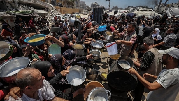 Crowds form as people, including children, line up in Gaza City, to receive food distributed by a charity