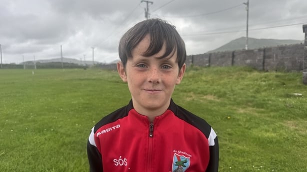 Seamus Ó'Suilleabháin stands on a gaelic pitch.