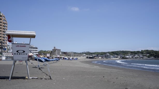 an empty beach in Japan with a lifeguard stand with a blue sky in the background