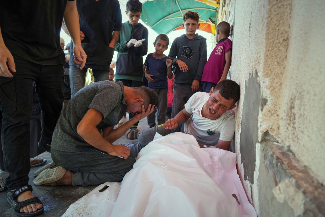 Relatives mourn over the bodies of Manal Abd Rabbo and her sister Fatima, who were among 15 people killed in an Israeli strike while queuing at a medical clinic run by Project Hope in Deir al-Balah, Gaza Strip, Thursday, July 10, 2025.