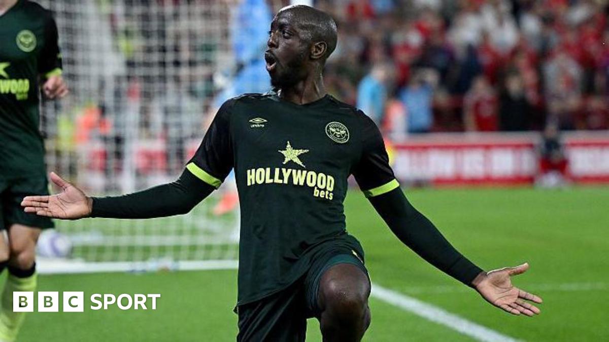 Yoane Wissa celebrates scoring for Brentford with one knee on the ground and his arms outstretched