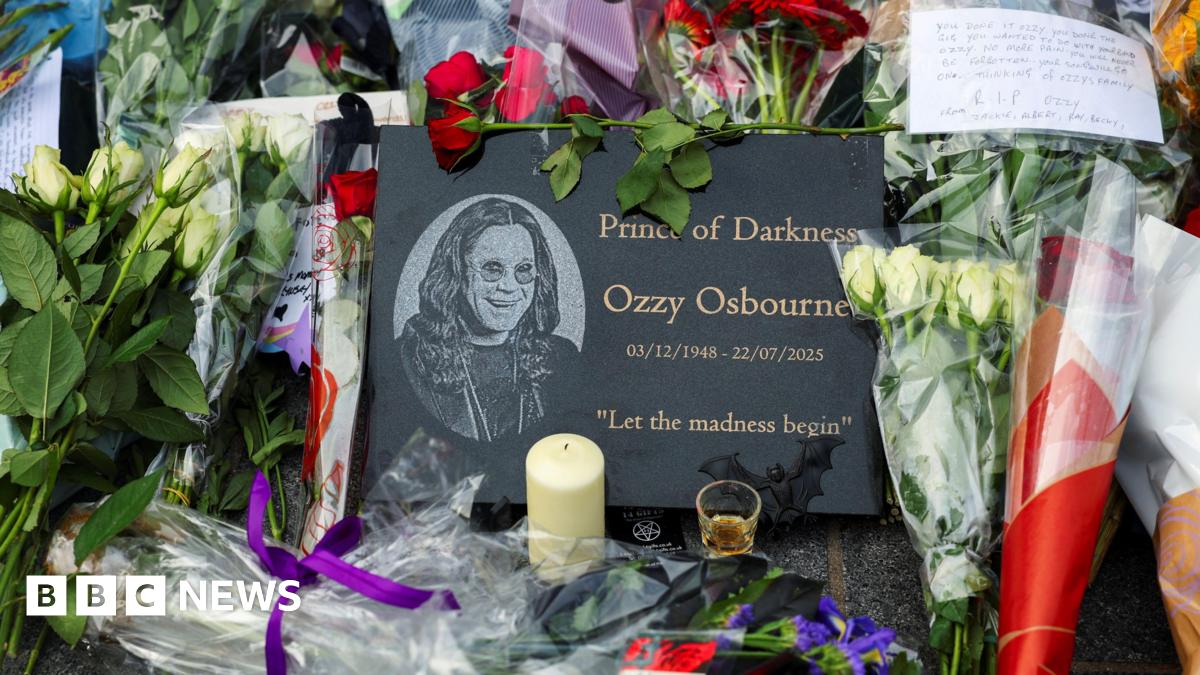 Flower tributes for Ozzy Osbourne in front a plaque that says Prince of Darkness, Ozzy Osbourne.