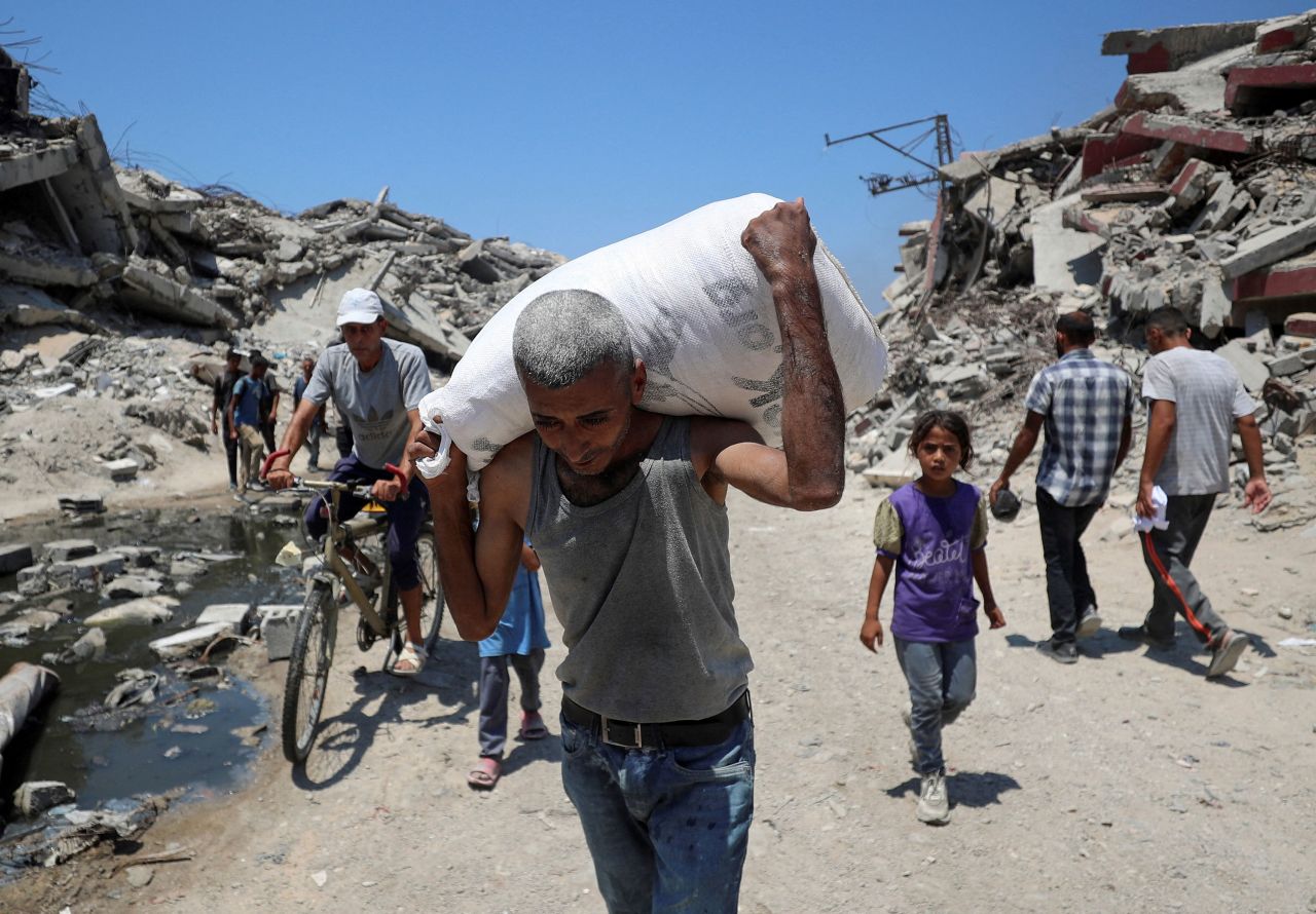 A Palestinian carries a bag with aid supplies that entered Gaza through Israel, in Beit Lahia in the northern Gaza Strip on July 27.