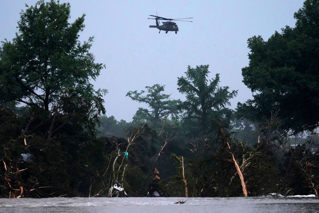 A helicopter flies over the Guadalupe River Friday in Kerrville, Texas. (AP Photo/Eric Gay)