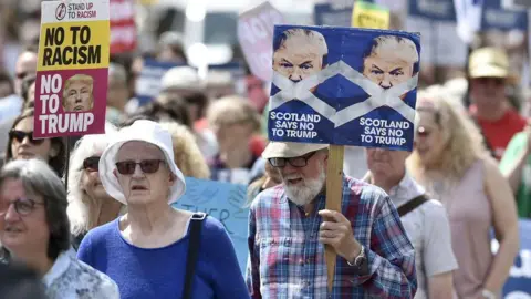 AFP A large group of people protesting against Donald Trump. One is carrying a placard which says 'No to racism - no to Trump'. Another carries one which says 'Scotland says no to Trump'. 