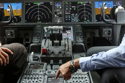 Bloomberg via Getty Images An employee, right, sits with a visitor inside the cockpit of a Boeing Co. 787 Dreamliner aircraft, operated by Air India Ltd., on display during the India Aviation 2014 air show held at the Begumpet Airport in Hyderabad, India, on Thursday, March 13, 2014. The air show takes place from March 12-16. Photographer: Dhiraj Singh/Bloomberg via Getty Images