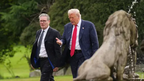 Getty Images U.S. President Donald Trump and British Prime Minister Keir Starmer walk together as they arrive at Trump International Golf Links