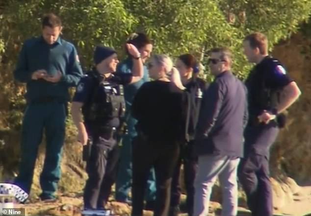 An investigation is underway after a woman's body was found floating in Currumbin Creek (pictured, emergency crews at the scene)