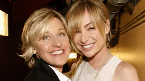 Getty Images Ellen and Portia de Rossi hugging, cheek to cheek, both smiling at the camera, backstage at the Daytime Emmy Awards in 2006