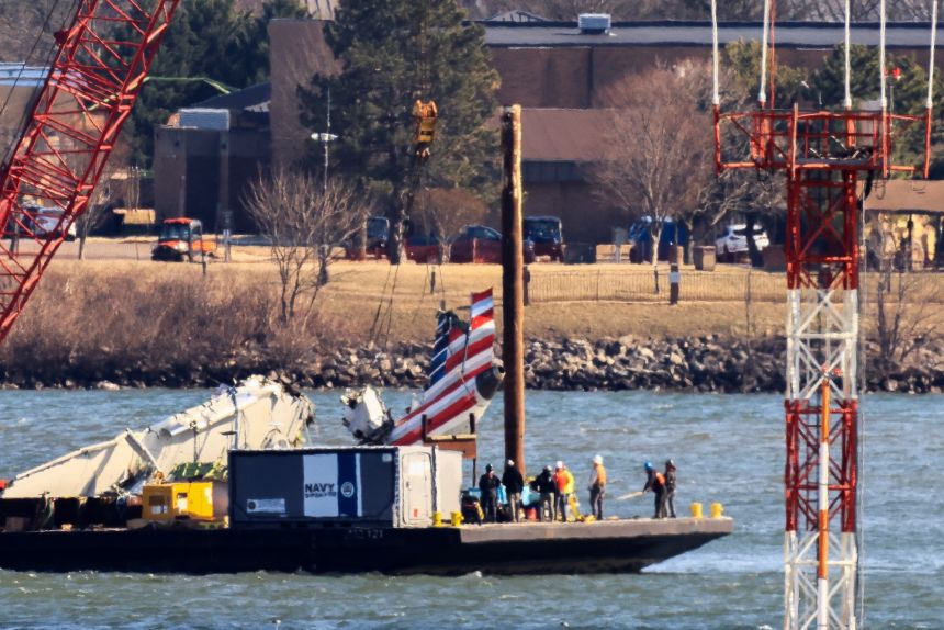 A crane retrieves part of the wreckage from American Airlines flight 5342, which was operated by PSA Airlines, on February 4, 2025.