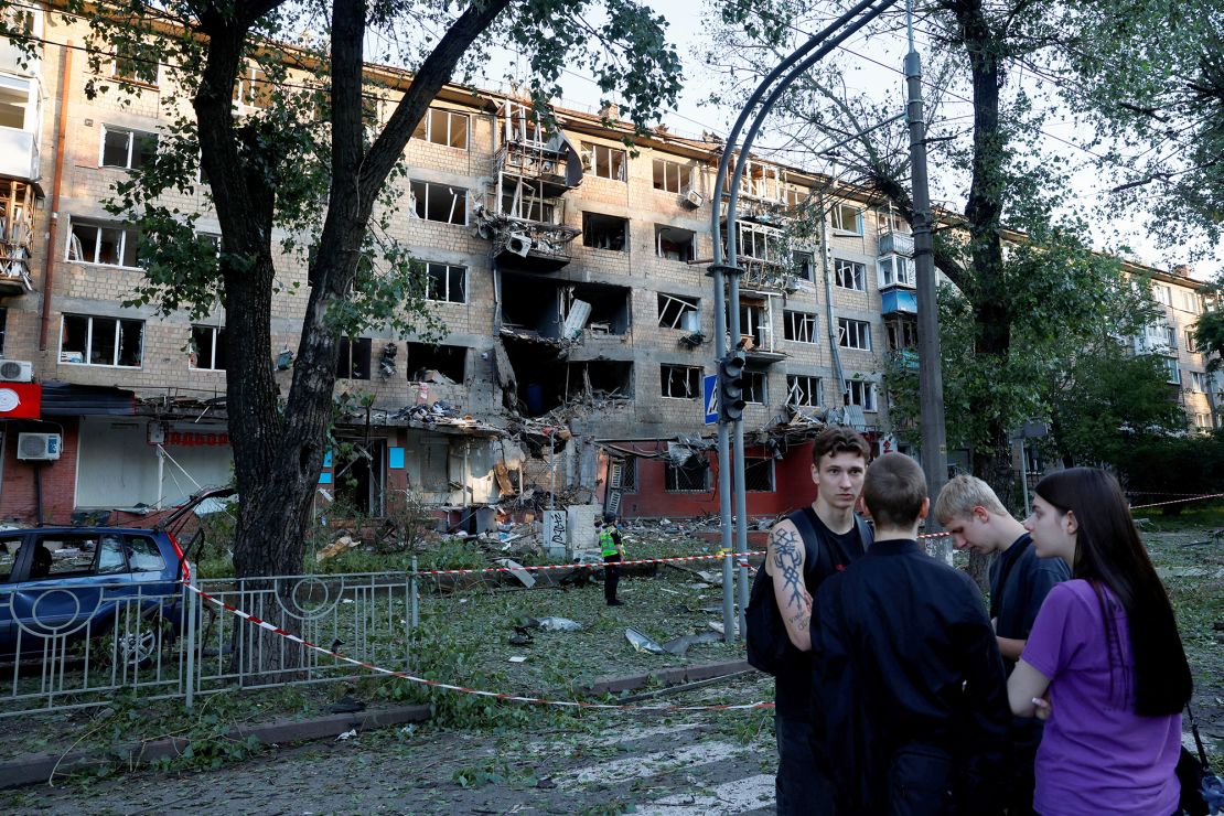 People gather near a building damaged during Russian drone and missile strikes in Kyiv.