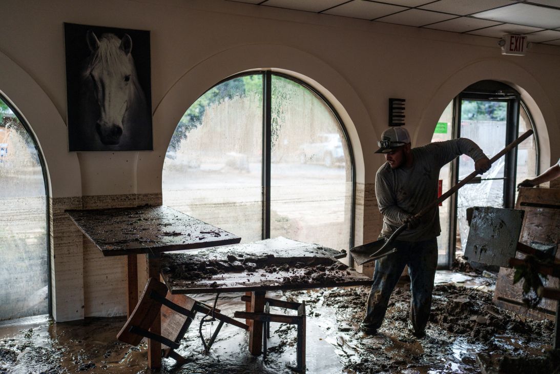 Omar Gutierrez, 31, helps clear debris from the inundated dining area of La Salsa Kitchen, a Mexican restaurant, after deadly flash flooding in Ruidoso, New Mexico, July 9, 2025.
