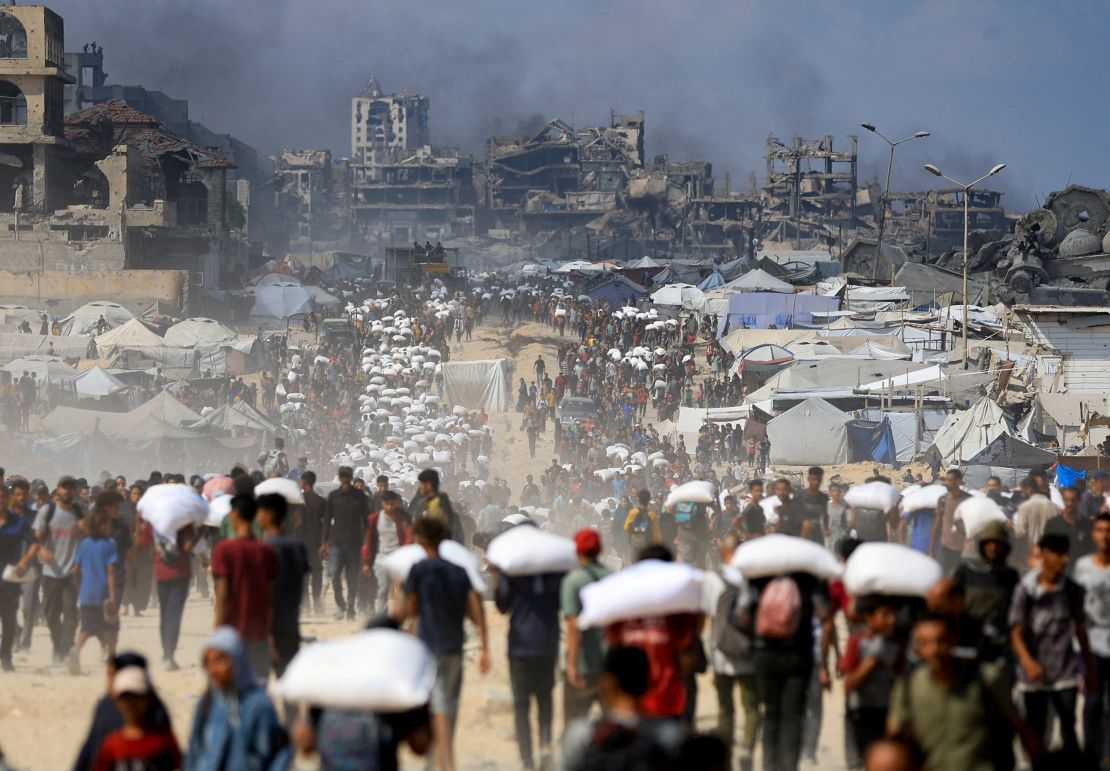 Palestinians gather as they carry aid supplies in Beit Lahia in the northern Gaza Strip on July 20, 2025.