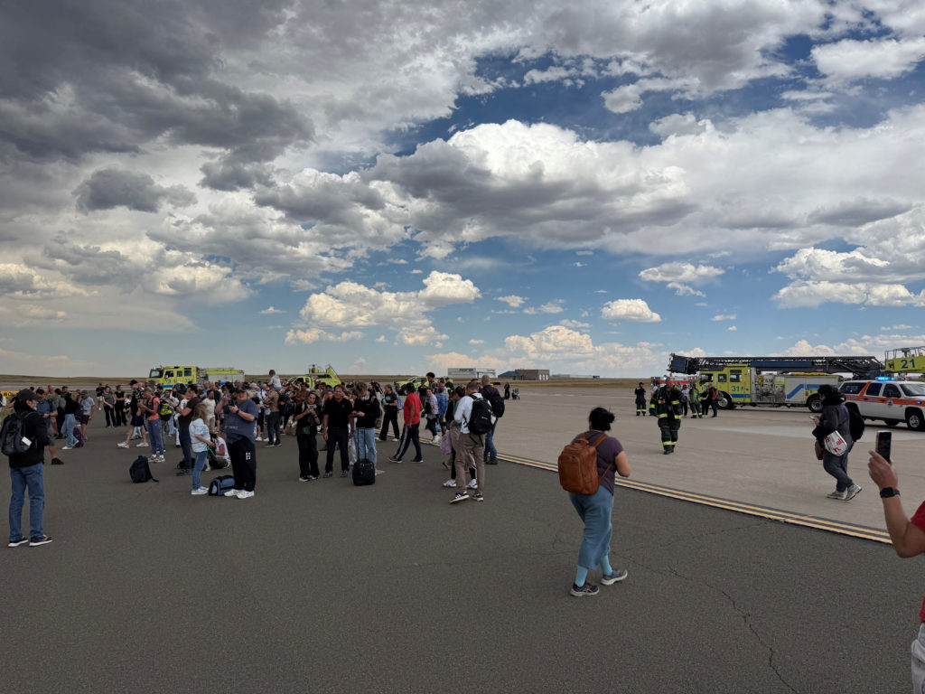 Passengers evacuate an American Airlines plane on a runway in Denver