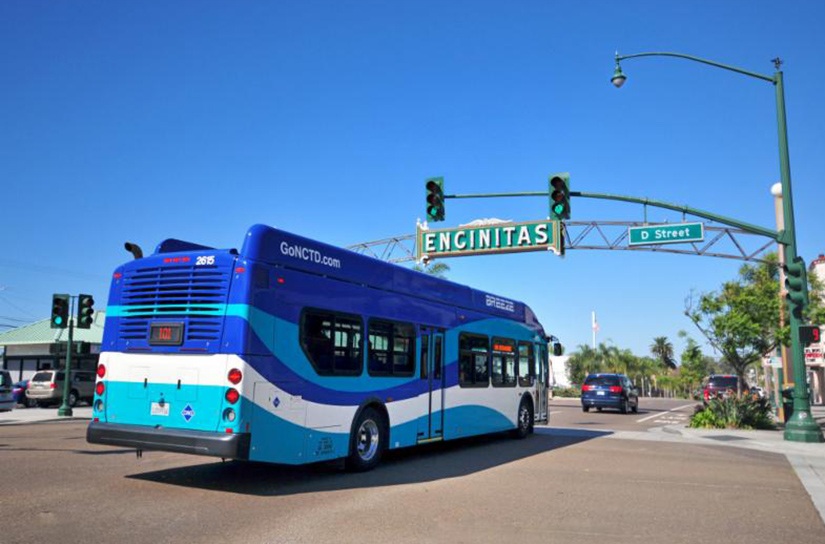 A bus drives under a sign that reads Encinitas.