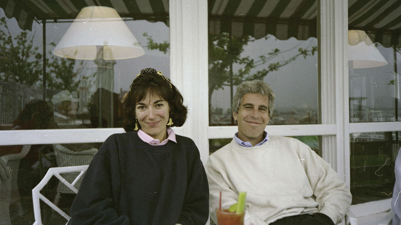An undated trial evidence image obtained December 2021, from the US District Court for the Southern District of New York shows British socialite Ghislaine Maxwell and US financier Jeffrey Epstein sat together in casual clothing at an outdoor table.
