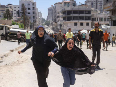 Two girls react after an Israeli strike hit a tent housing displaced Palestinians, in Gaza City, on July 8, 2025.