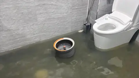 Kim Ha-min Floodwaters have inundated the toilet in Kim Ha-min's cafe in Gwangju