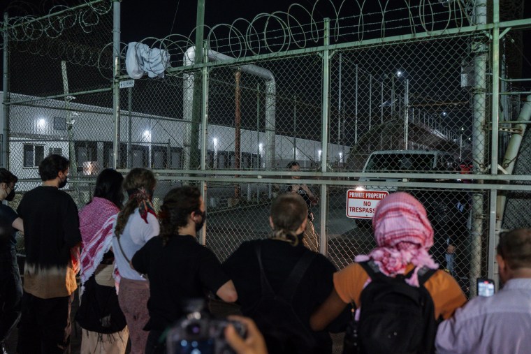 Protesters link hands at the gates