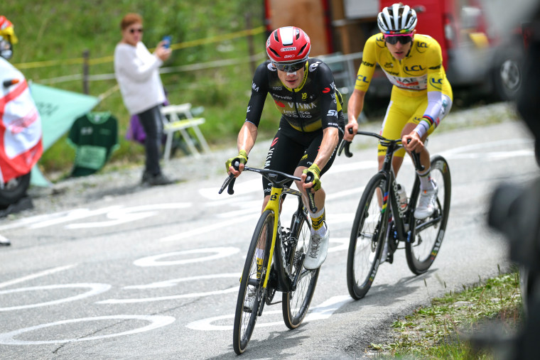 Jonas Vingegaard rides a bicycle on the street in front of Tadej Pogacar
