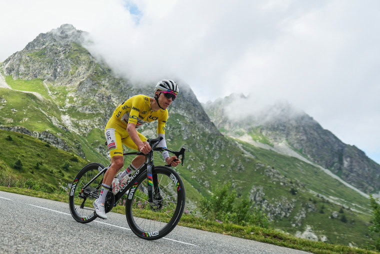 Tadej Pogacar rides on a bicycle down the road on a hill