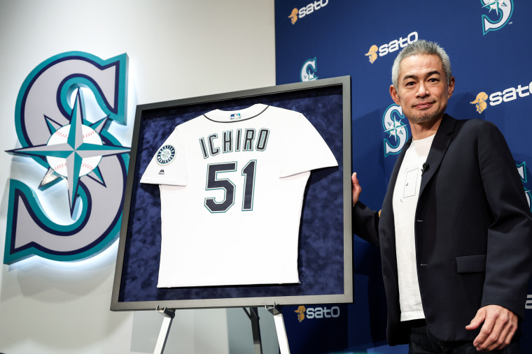 Ichiro Suzuki poses next to his framed #51 jersey of the Seattle Mariners