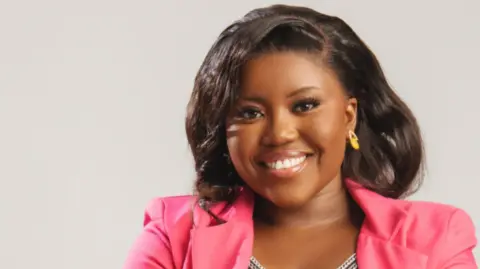 Courtesy of Falone Ngu A woman wearing a pink blazer smiles for the camera.