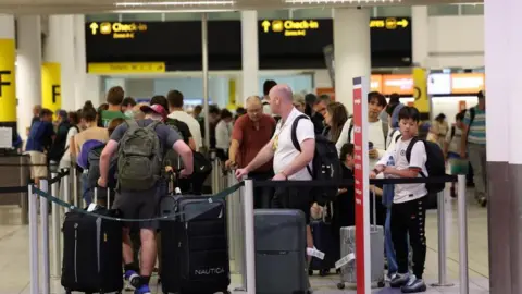 EPA Passengers queue to check in at Gatwick Airport in Crawley on 30 July 2025