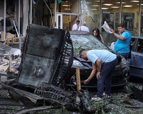Residents inspect a damaged car at the site of the Russian drone strike, amid Russia's attack on Ukraine, in Odesa, Ukraine.