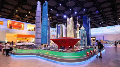 Getty Images Visitors view a Lego miniature of the Shanghai skyline at the Legoland Shanghai Resort. The miniature, set up within a convention hall, stands at least six metres tall. 
