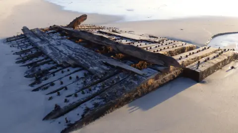 PA Media Wooden ship wreck on a beach