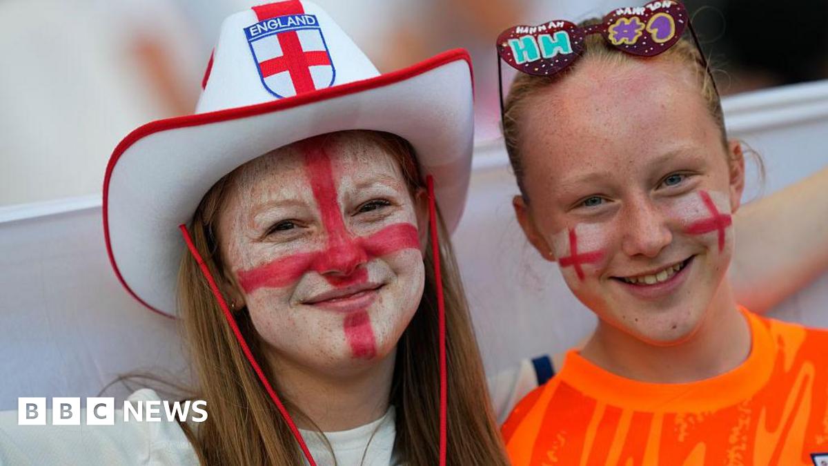 A woman and a young girl are pictured wearing an England hat, novelty sunglasses and red and white face paint prior to the UEFA Women's Euro 2025 semi-final match between England and Italy at Stade de Geneve on July 22, 2025