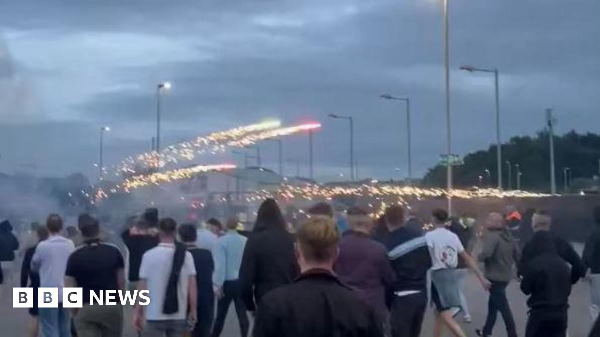A crowd of people with fireworks exploding over them.